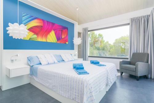 a bedroom with a bed and a chair and a large window at Finca Son Baulo in Santa Margalida