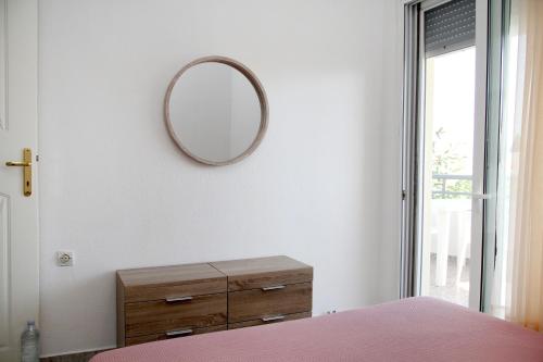 a bedroom with a dresser and a mirror on the wall at Apartment for Family 2 in Kallithea Halkidikis