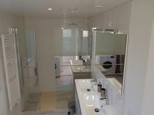 een witte badkamer met een wastafel en een spiegel bij Ty Theven in Plouescat