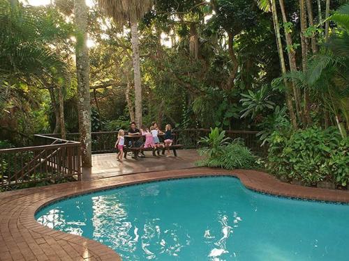 a group of people sitting on a bench by a pool at 42 Ramsgate palms in Margate