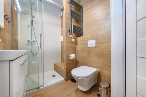a small bathroom with a toilet and a shower at Bursztynowe Osiedle Jantar, Sun & Snow in Jantar