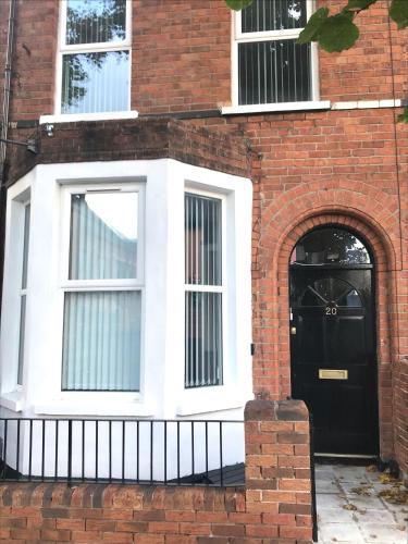 a brick house with a black door and an archway at Castleton townhouse in Belfast