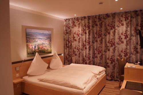 a bedroom with a bed and a curtain at Hotel Gasthof Luis in Warburg