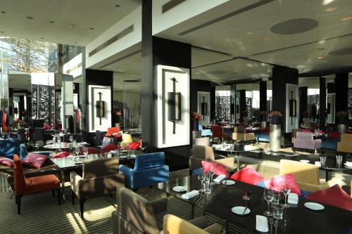 a restaurant with tables and chairs in a room at Sofitel Casablanca Tour Blanche in Casablanca