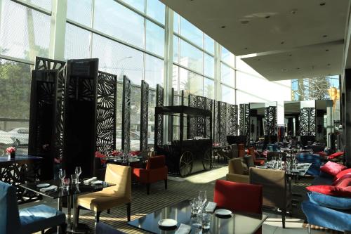 a restaurant with tables and chairs and windows at Sofitel Casablanca Tour Blanche in Casablanca