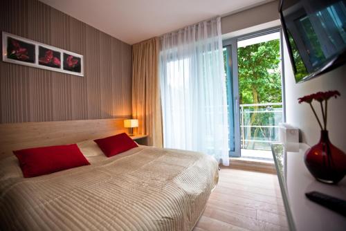 a bedroom with a large bed and a large window at Luksusowe apartamenty Promenada Gwiazd 28 in Międzyzdroje