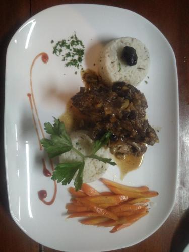 a plate of food with meat and vegetables on it at Andasibe Lemurs Lodge in Andasibe