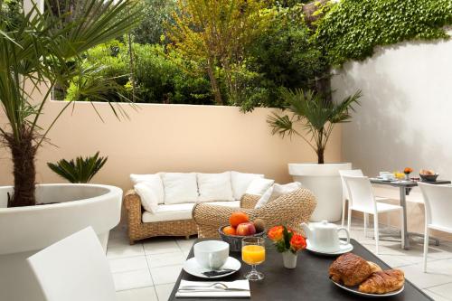 a patio with a couch and a table with food at Le Gamaritz in Biarritz