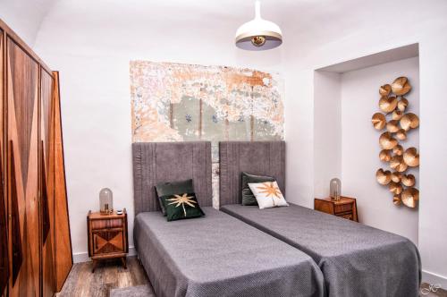 a bedroom with a bed with gray sheets and pillows at Casa Porta D`Aviz in Évora