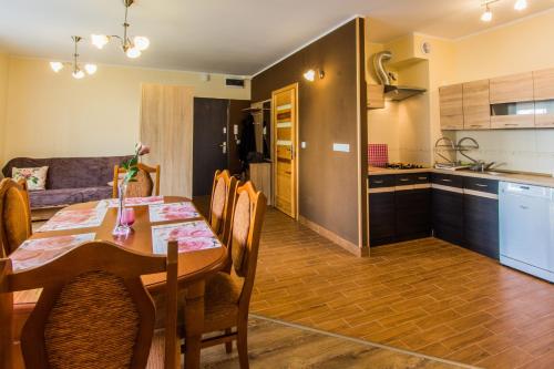 a dining room and kitchen with a table and chairs at Apartamenty Izerskie - ul. Cicha 13F-G in Świeradów-Zdrój