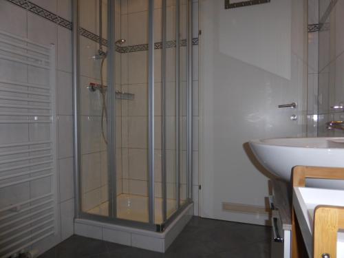 マウテルンドルフにあるLuxusappartement Haus 157のバスルーム(ガラス張りのシャワー、シンク付)
