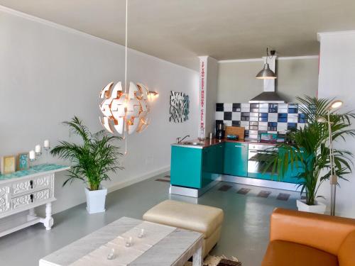 ein Wohnzimmer mit einem Tisch und einem Kronleuchter in der Unterkunft Casa Flamingo, Sea View Apartment in Puerto del Carmen