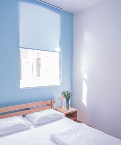 a blue bedroom with a bed and a window at DREAM Hostel Kyiv in Kyiv