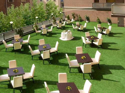 a group of tables and chairs on a lawn at Suite Hotel Elite in Bologna