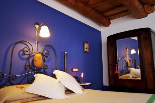 a blue bedroom with a bed and a mirror at Casa Pepa Hotel Rural in Santa Colomba de Somoza