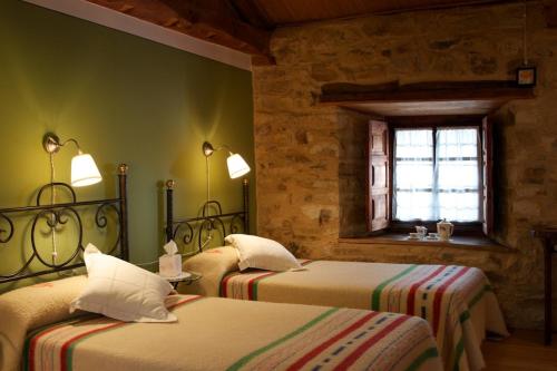 a bedroom with two beds and a window at Casa Pepa Hotel Rural in Santa Colomba de Somoza