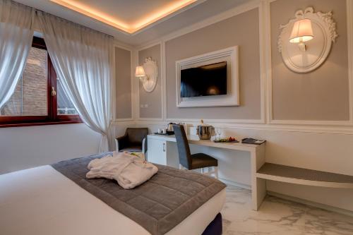 a hotel room with a bed and a desk at Grande Albergo Roma in Piacenza