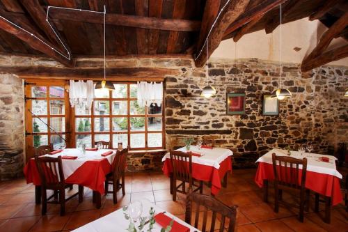 a dining room with tables and chairs in a stone building at Casa Pepa Hotel Rural in Santa Colomba de Somoza