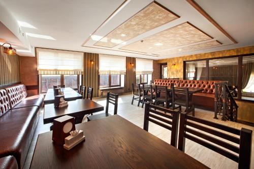 a restaurant with benches and tables and chairs at Hotel Gentleman in Ternopilʼ