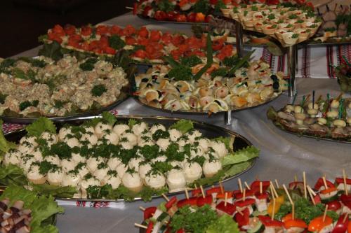 una mesa con muchos tipos diferentes de comida en ella en Комплекс відпочинку "Колиба" en Korostenʼ