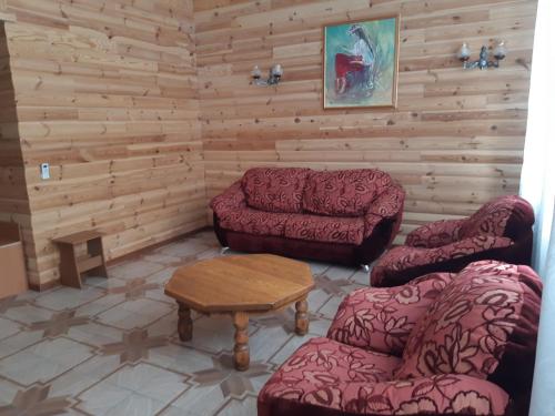 a living room with two couches and a table at Комплекс відпочинку "Колиба" in Korostenʼ