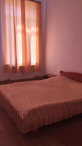 a bedroom with a bed and a window with a curtain at Комплекс відпочинку "Колиба" in Korostenʼ