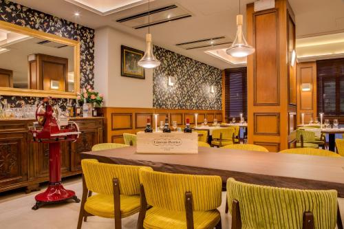 a restaurant with a large wooden table and yellow chairs at Grande Albergo Roma in Piacenza