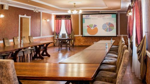 a conference room with tables and chairs and a screen at Hotel Gentleman in Ternopilʼ