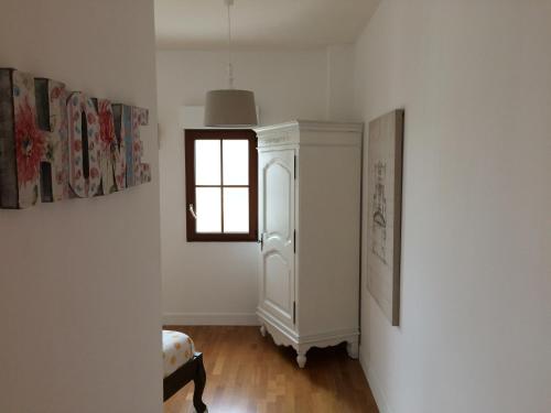 a room with a white cabinet and a window at LA VILLA BOLERO in Saint-Cyr-sur-Loire