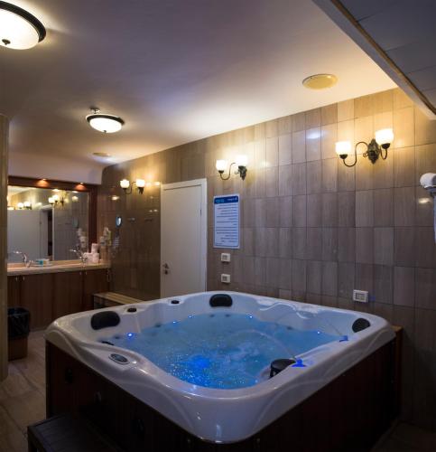 a bathroom with a large tub with blue water at Kinorot Hotel in Tiberias
