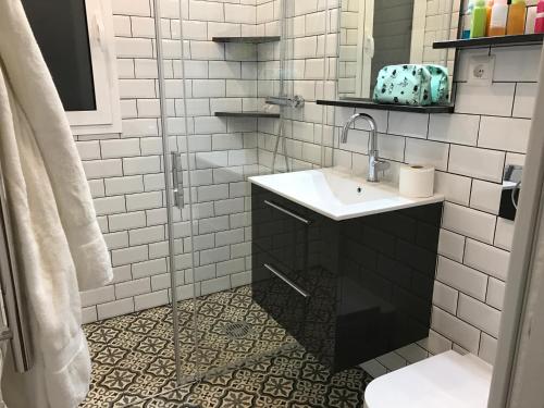 een wit betegelde badkamer met een wastafel en een spiegel bij Nerja · Nerja · Beautiful seaview apartment Nerja in Nerja