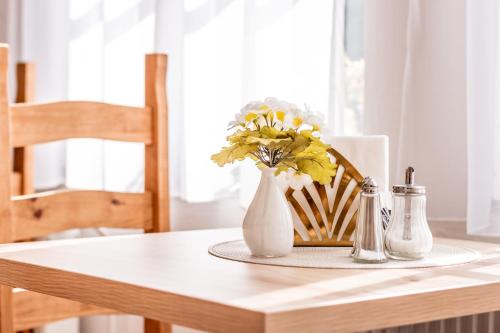 a table with a white vase with flowers in it at Familia in Český Krumlov