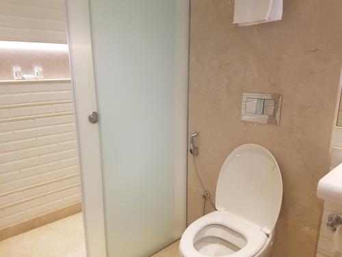 a bathroom with a toilet with the lid up at Hotel Harbour View Colaba in Mumbai