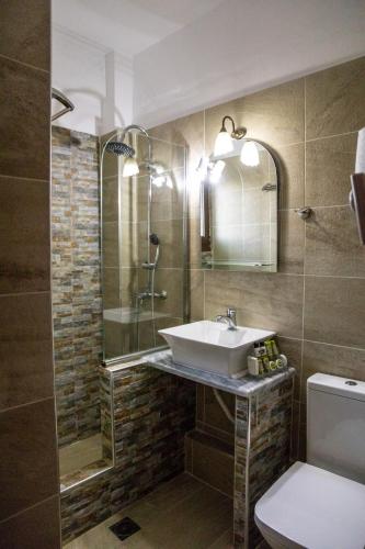 a bathroom with a sink and a shower and a toilet at Tasia Mountain Hotel in Chania