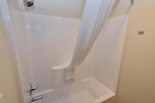 a white shower with a white curtain in a bathroom at Cobblestone Inn & Suites - Manning in Manning
