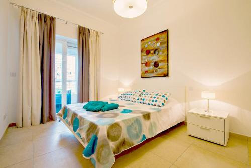 a bedroom with a bed with a lamp and a window at Luxury Apartment with Pool in Sliema