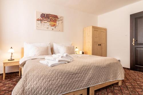 ein Schlafzimmer mit einem Bett mit Handtüchern darauf in der Unterkunft Familia in Český Krumlov
