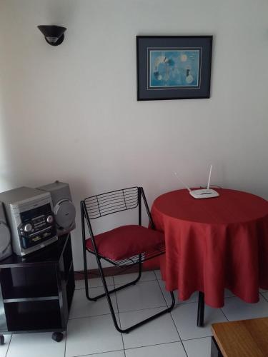 a room with a table and a chair with a red table cloth at Apart Antofagasta in Antofagasta