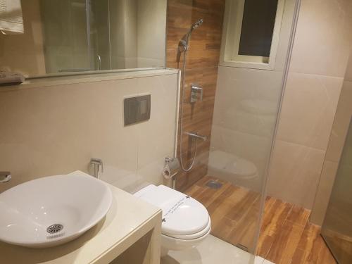 W łazience znajduje się umywalka, toaleta i prysznic. w obiekcie Hotel Suncity Apollo, Colaba w Bombaju