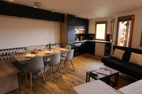 a kitchen and living room with a table and a couch at Temples du Soleil Nazca Appartements VTI in Val Thorens