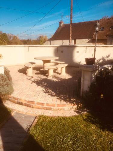 a patio with a picnic table in front of a building at gite du vieux bourg in Le Vieux Bourg