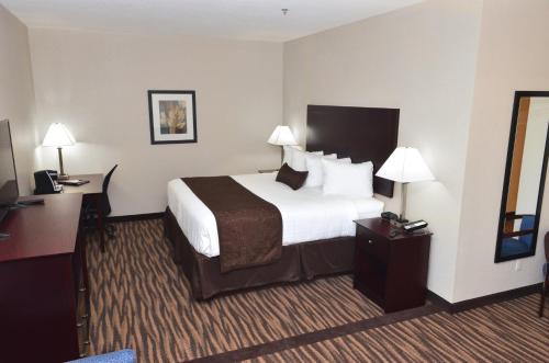 a hotel room with a large bed and a desk at Cobblestone Inn & Suites - Manning in Manning