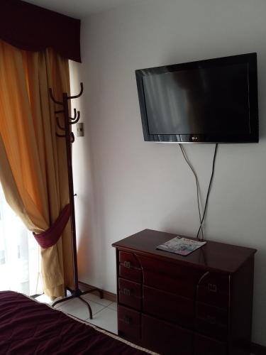 a bedroom with a flat screen tv on the wall at Apart Antofagasta in Antofagasta
