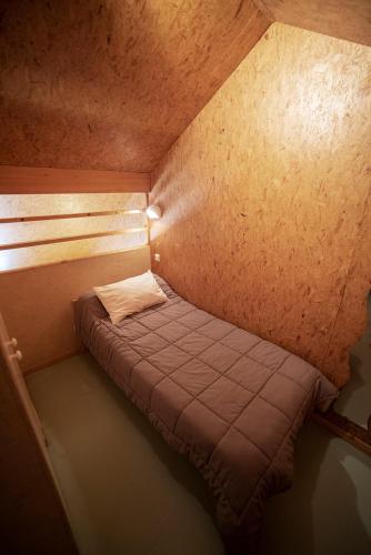 a small bed in the corner of a room at Le Pas de L'Ours in Aston