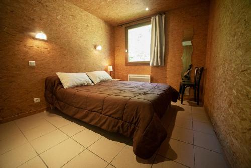 a bedroom with a bed in a room with a window at Le Pas de L'Ours in Aston