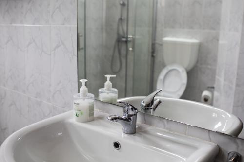 La salle de bains est pourvue d'un lavabo, d'un miroir et de toilettes. dans l'établissement Praia Accommodation, à São Tomé
