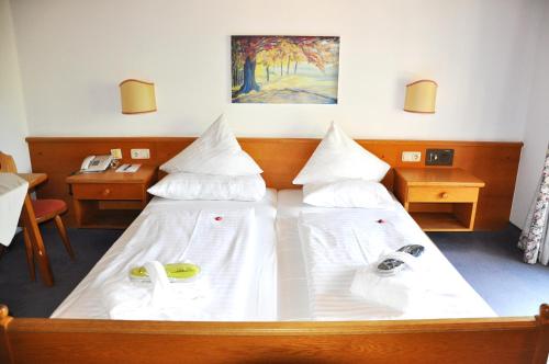 a bedroom with two beds with white sheets at Stammhaus im Hotel Alpine Palace in Saalbach Hinterglemm