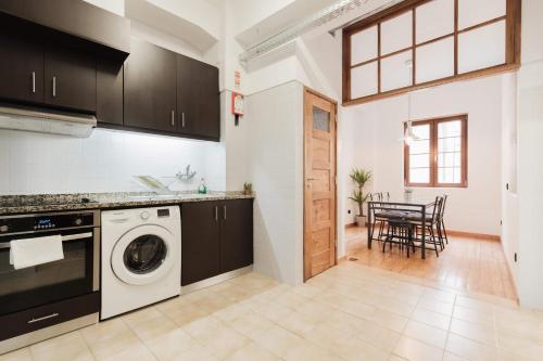 a kitchen with a washing machine and a dining room at Puro Apartment in Porto