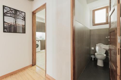 a bathroom with a toilet and a glass door at Puro Apartment in Porto