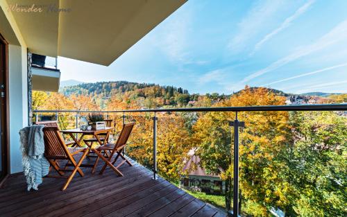 a balcony with a table and chairs on a deck at Wonder Home - Apartamenty z balkonami, blisko centrum Karpacza, stoku i aquaparku in Karpacz
